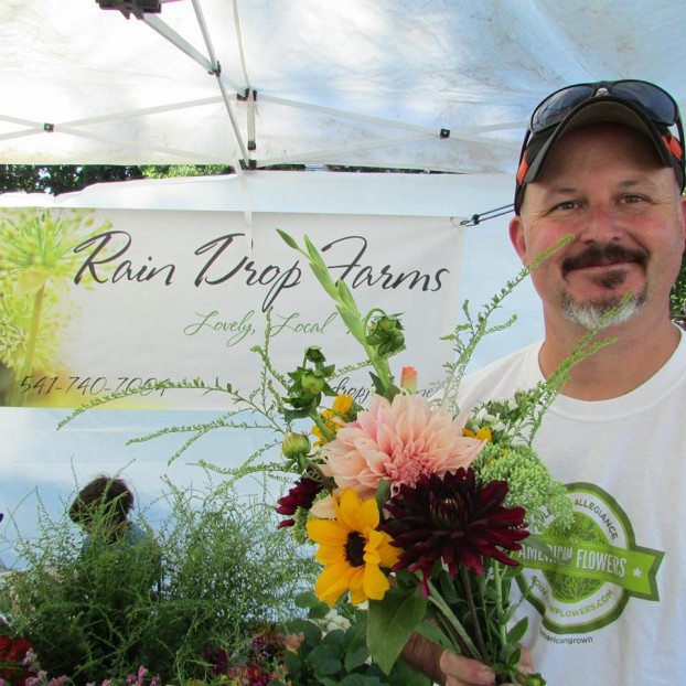Aaron Gasky at the Rain Drop Farms' farmers' market stall. Notice he's wearing a Slow Flowers t-shirt!