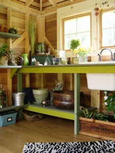A lime green potting bench, situated beneath the cottage-style windows