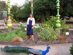 Artist and sculptor Leslie Codina, with peacock strolling by