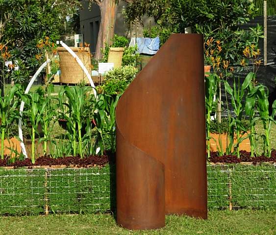 Jennifer Asher of Terra Sculpture, used sedum and woolly thyme to build a modern, horizontal planting box for corn. Showcased in front is "Taffy"; and behind is "Embrace"