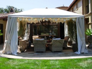 A custom tent with side draperies and scalloped details creates a secluded, breezy patio retreat