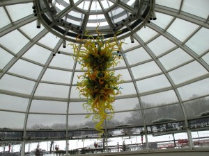 Chihuly's brilliant chandelier in mimosa yellow hangs from the ceiling of the new entry