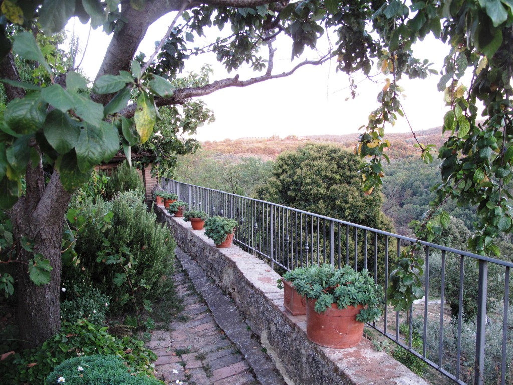 The railing is mounted on top of the stone wall at the perimeter of the patio. Love the pots!