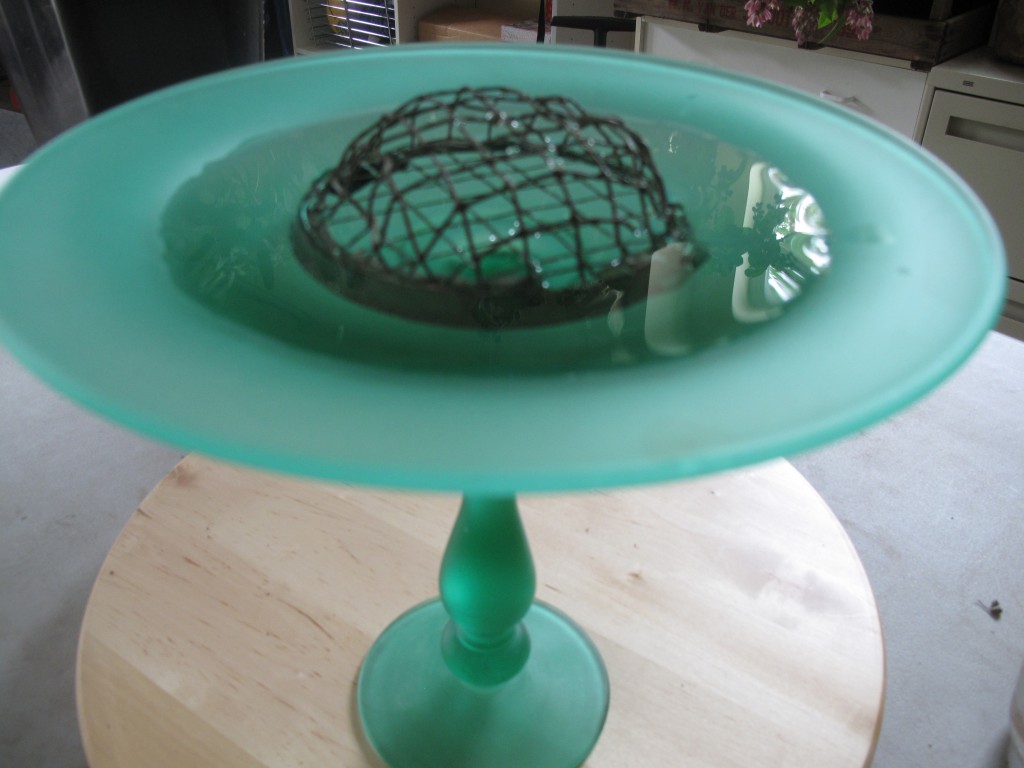 Then insert the frog in the shallow base of the bowl or stand and add water.