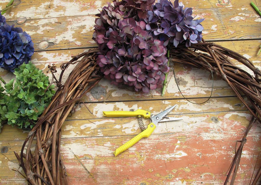 Start by wiring individual flowers to the grapevine wreath base.
