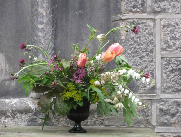 The green glass vase contains an exhuberant display of spring Yorkshire flowers - and captures a moment in time as I clipped and designed with flowers from Sarah and James's garden.