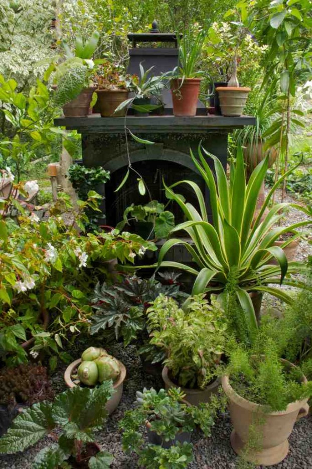 From page 223 of The New Shade Garden: Ken repurposed an outdoor fireplace as a staging platform for his summering houseplants.
