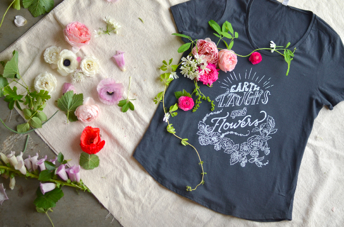 "Earth Laughs in Flowers," a soft, flattering, American-made T-shirt with a charming hand-lettered message.