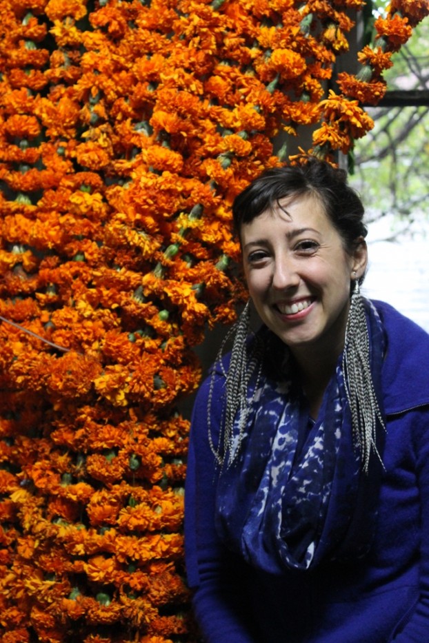 Holly Rutt, of Sweet Pea Floral Design, posing with the marigold "shower curtain" in "In Loo of Flowers"