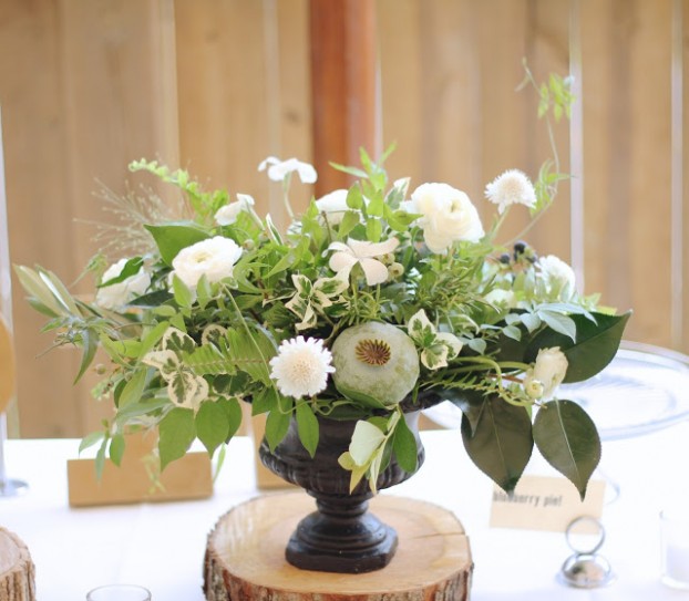 Suzy and Joe's wedding was the perfect opportunity for Holly design with locally grown flowers from Detroit farms like Fresh Cut flower farm and Ann Arbor's Seeley Farms. "These have got to be some of my all time favorite centerpieces and bouquets with lush textured foliages including home grown jasmine vine, wild blueberry, variegated pittospurmum, rosemary, explosion grass camellia, ferns, and olive branches," Holly says. "The giant poppy pods gave each piece its focal point and the wild scabiosa and ranunculus prettied it all up."