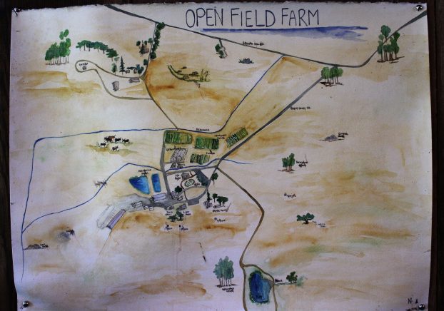 A hand-illustrated map of Open Field Farm hangs inside the gathering barn