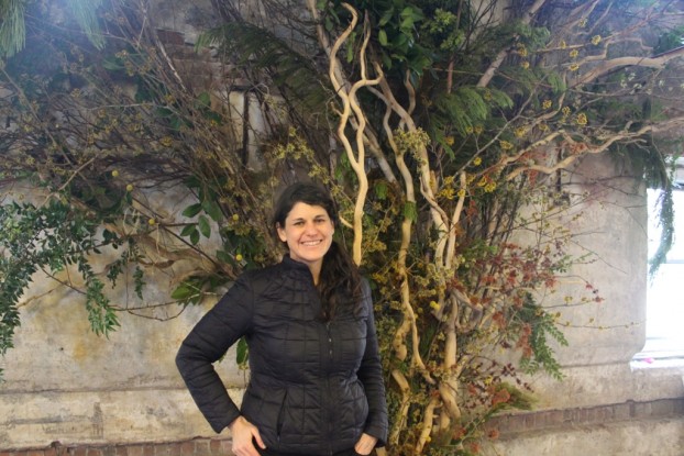 Lisa Waud, artist, innovator, entrpreneur, floral designer and creator of The Flower House (Detroit). She's standing in front of the base of the tree-inspired sculpture installed by her students at the Seattle Wholesale Growers Market.