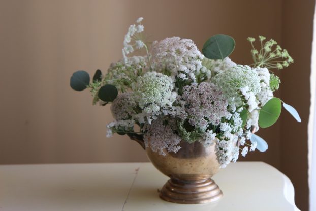 Create a snowy scene with whites and silvery hues. Betany Coffland of Chloris Floral in Sonoma County, California, designed a winter-themed arrangement using white and pink Queen Anne's lace, white statice and silver dollar eucalyptus foliage. 