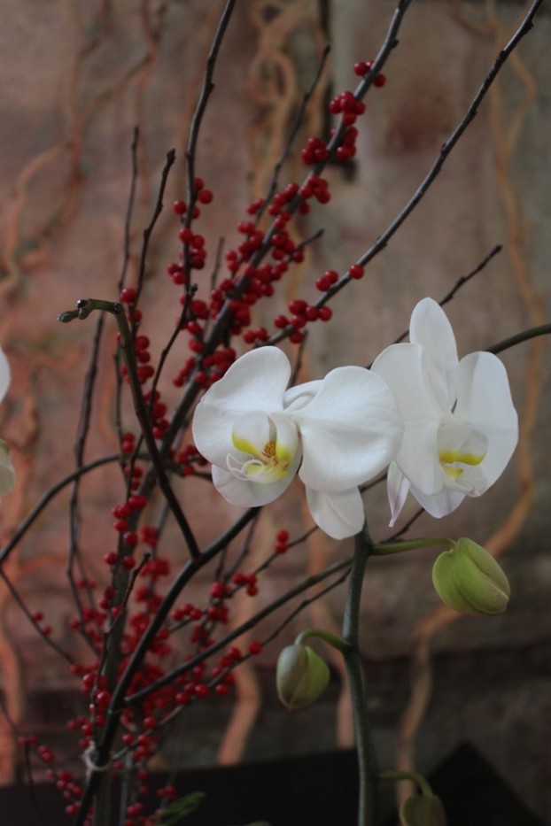 White phalaenopsis from Orchidaceae paired with red ilex from Charles Little & Co., designed by Chad Burnworth of Seattle-based Blue Hummingbird Botanical Studio.